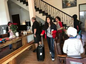 a woman walking down the stairs with a suitcase at De Daisy Villa Homestay in Da Lat