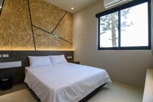 湖西鄉的住宿－夏日瘋民宿，一间卧室设有一张大床和一个窗户。
