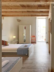 a bedroom with two beds and a large window at Le Fiche d’India in Giuggianello