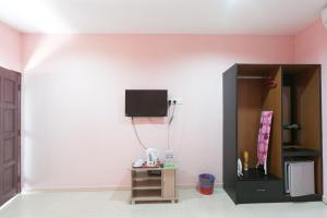 um quarto com uma parede com uma televisão em Sri Melor Inn em Pantai Cenang