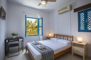 um quarto com uma cama e duas mesas e uma janela em Protaras Ayios Elias Suite em Protaras