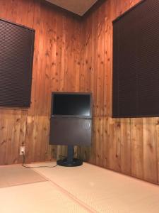 Kocchi tei في Tsuru : تلفزيون في غرفة بجدران خشبية