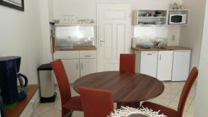 ヴァーネミュンデにあるApartment Strandgangのキッチン(木製テーブル、赤い椅子付)