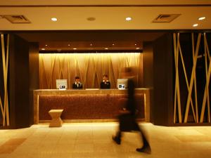 a person walking in front of a hotel lobby at Hotel Metropolitan Yamagata in Yamagata