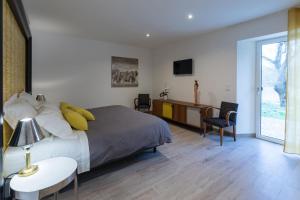 a bedroom with a bed and a desk and a tv at Chut ! c'est ici in Venelles