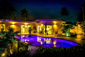 a house with a swimming pool at night at The Inspiration Residence in Rawai Beach