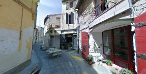 eine Gasse mit Tischen und Stühlen auf einer Straße in der Unterkunft Cueva in Arles