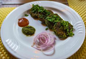 un piatto bianco con del cibo su un tavolo di Hathi Mauja a Jaipur