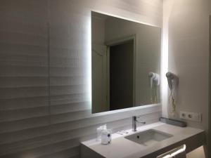 bagno con lavandino e specchio di Hotel Playa Santandria Adults Only a Cala Santandria