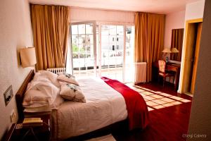 a hotel room with a bed and a balcony at Hotel Pintor Marsà in Tárrega