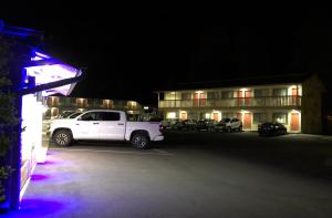 a white truck parked in a parking lot in front of a hotel at Mountain View Inn in Flagstaff