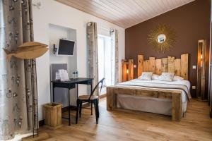 a bedroom with a bed and a desk in a room at Hôtel Le Peu Breton in Sainte-Marie-de-Ré