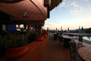 a patio of a restaurant with tables and potted plants at Hotel Montetaxco in Taxco de Alarcón