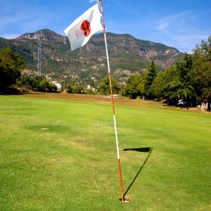 a flag on a golf course with mountains in the background at Hotel Montetaxco in Taxco de Alarcón