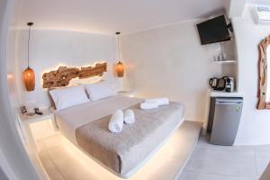 a bedroom with a bed with two white towels on it at Villa Elina suites and more in Agios Stefanos