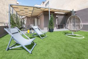 two lounge chairs and a fan on a lawn at Acropolis Stay in Athens