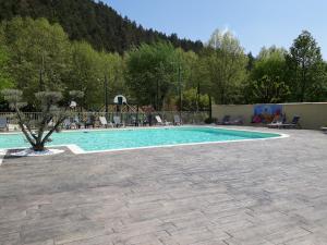 a swimming pool with chairs and a playground at Camping de Retourtour in Lamastre +78 photos