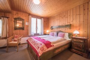 una camera con un letto e una sedia di Hotel Fassbind Beausite a Beatenberg
