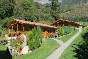 a couple of wooden buildings in a green field at Winklerhof in Parcines