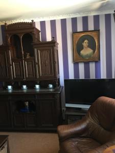 ein Wohnzimmer mit einem TV und einem Gemälde an der Wand in der Unterkunft Hotel Kardinal in Winnyzja