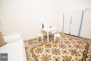 um quarto com uma mesa e dois bancos num tapete em Le luminarie em Mottola