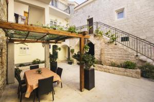 an outdoor patio with a wooden table and chairs at Apartments Dvor - ap1, ap2, ap3 in Baška Voda