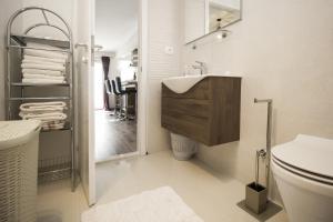 a white bathroom with a sink and a toilet at Apartments Dvor - ap1, ap2, ap3 in Baška Voda