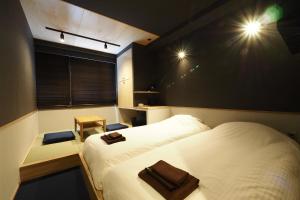 箱根町にあるユモトステーションホテル MIRAHAKONEのベッド2台と窓が備わる小さな客室です。