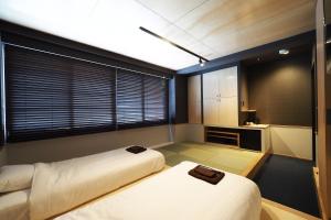 two beds in a small room with a kitchen at Yumoto Station Hotel MIRAHAKONE in Hakone