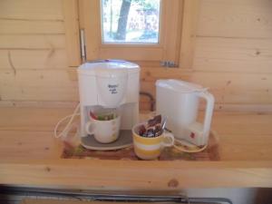 Vakantiepark 't Urkerbos - Kabouterhuisje في أورك: آلة صنع القهوة وكوبين على منضدة