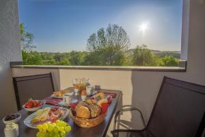 uma mesa com pão e fruta numa varanda em Ferienwohnung Dorfbrunnen em Merzig