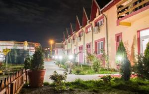 a row of pink buildings at night with lights at Casa Regala EAR in Craiova