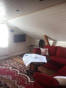 un soggiorno con divano rosso e TV di Ferieleilighet på Tromøy, Arendal ad Arendal