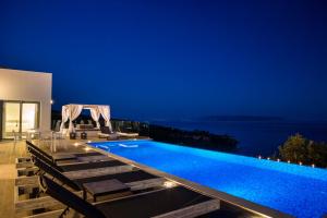 una villa con piscina di notte di Mystique View Villas a Lourdata