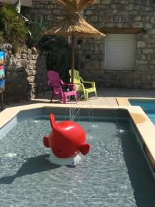 a pool with a red rubber animal in the water at Camping Chalets Les Chênes Verts in Vogüé