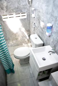 タオ島にあるDPM Koh Tao Diving Hotel & Barの白いトイレと洗面台のあるバスルーム