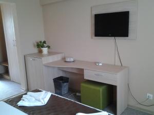 a room with a desk with a television on the wall at Hostel Nova Route in Mamaia Sat/Năvodari +10 photos