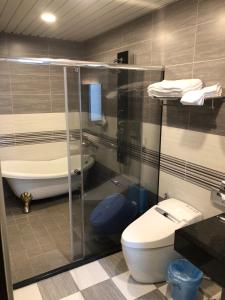 a bathroom with a toilet and a bath tub at Childlike Innocence Homestay in Ji'an