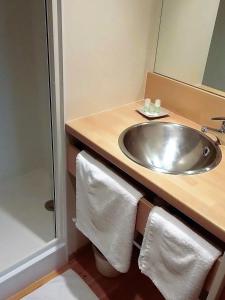 La salle de bains est pourvue d'un lavabo et d'un miroir. dans l'établissement Domaine des Cadets de Gascogne, à Pauilhac