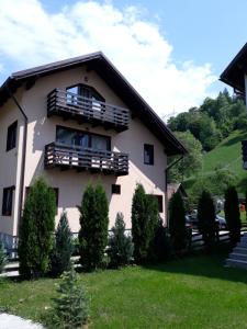 a house with a balcony on a hill at Apartament Laura in Bran