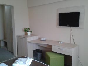 a hotel room with a desk with a tv on the wall at Hostel Nova Route in Mamaia Sat/Năvodari