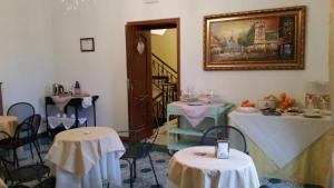 ジョイオーザ・イオーニカにあるB&B Palazzo Mantegnaのテーブルと椅子、壁画が備わるお部屋