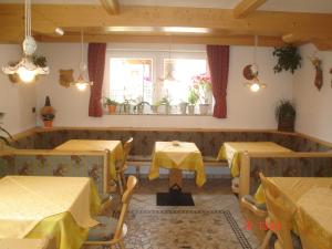 a restaurant with two tables and a window at Garnì Villa Cecilia in Mazzin