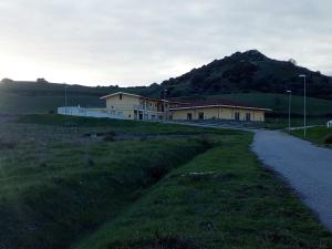 a house on a hill next to a road at Hotel Bena e Traes in Laerru