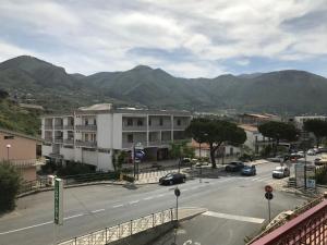 a view of a street with a building and mountains at La casa del Professore in Tortora