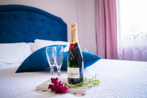 a bottle of wine and two glasses on a bed at Relais Villa Italia in Selcetta