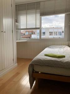 a bedroom with a bed and a large window at Puerto 9 in Huelva