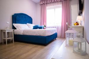 a bedroom with a blue bed and a window at Relais Villa Italia in Selcetta