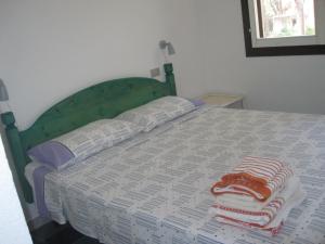 a bed with a green headboard and two pillows on it at Villetta Vista Mare Calaverde IUN Q0265 in Santa Margherita di Pula