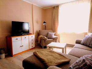 ein Wohnzimmer mit einem Sofa und einem TV auf einer Kommode in der Unterkunft house46-1 in Hohen Neuendorf
